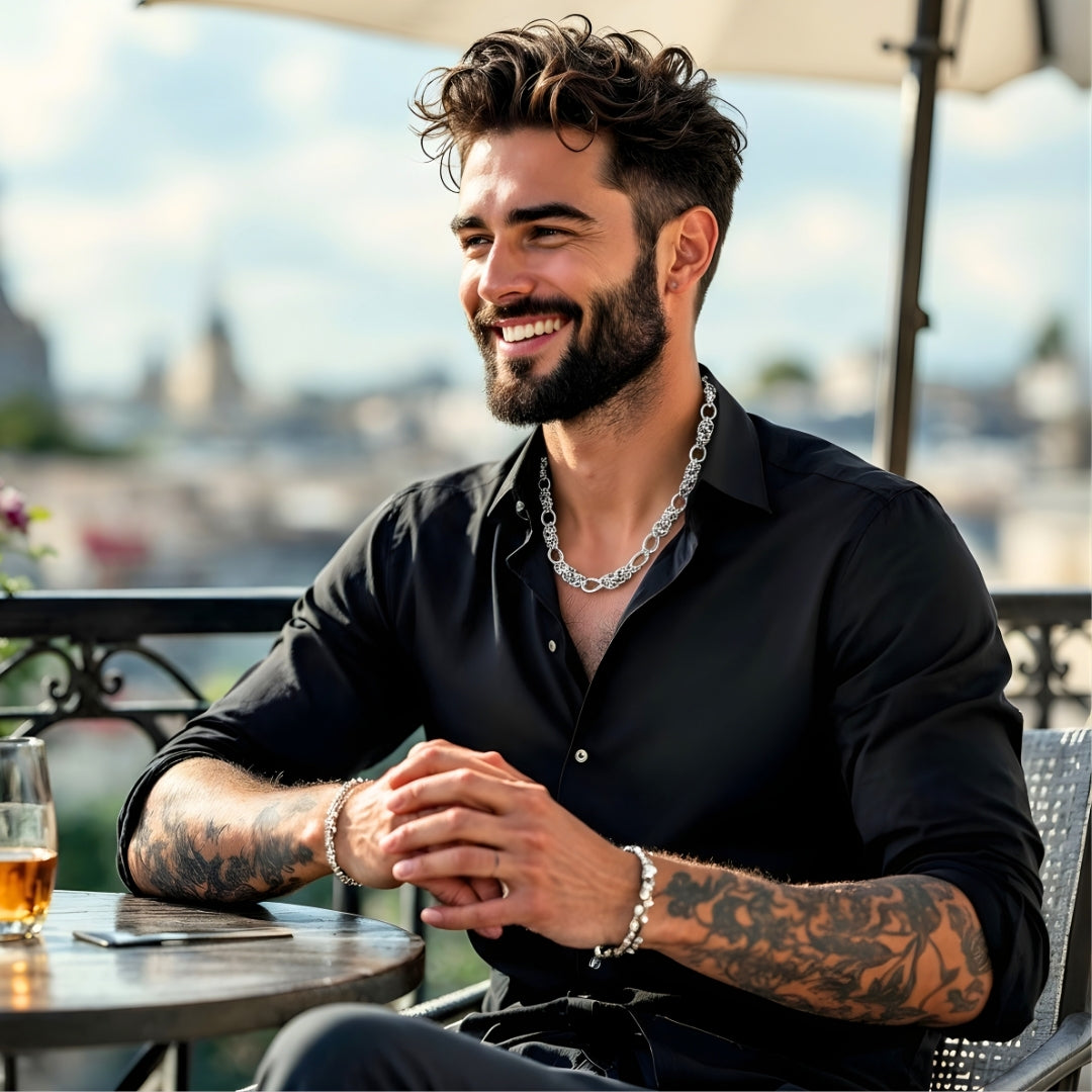 Chaine homme collier maillons entrelacés alterné argent homme souriant chemise noir aloccol terrasse