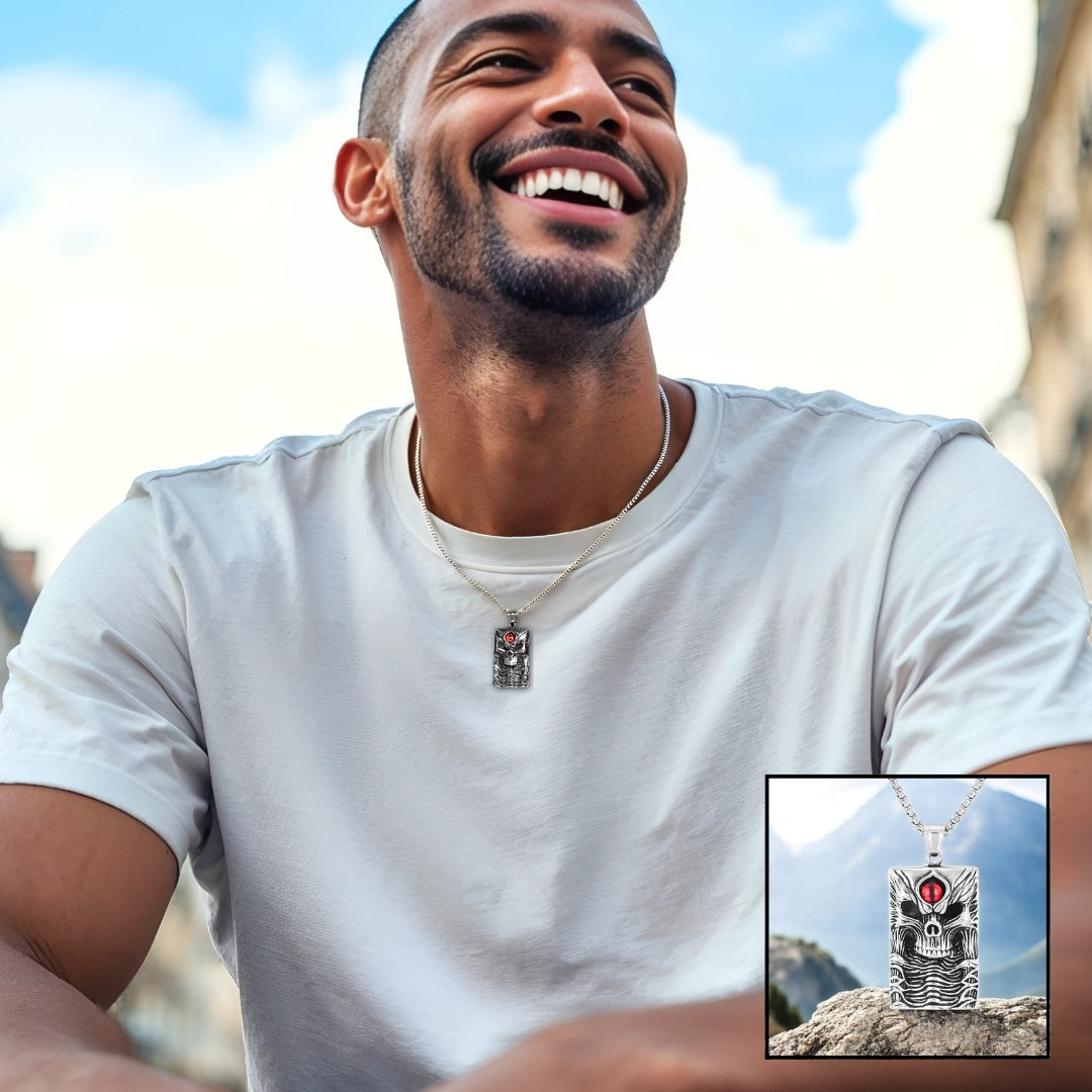 Collier homme- pendentif- tête de mort- skull- homme-élégant-t-shirt-blanc- barbe- assied- à- Paris- ciel bleu-sourire