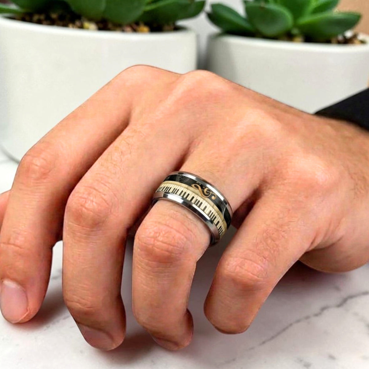 Bague tendance homme piano et clé de sol dorée main table marbre 