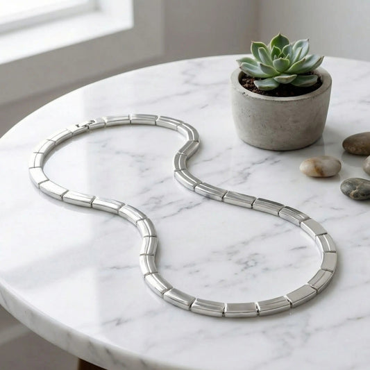 Chaîne, collier homme maille barrette articulee argent table marbre 