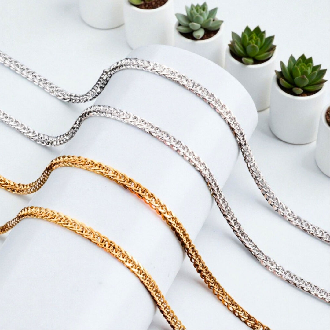Chaîne homme, Collier à anneaux serrés dore argent presentation rouleau blanc plantes 