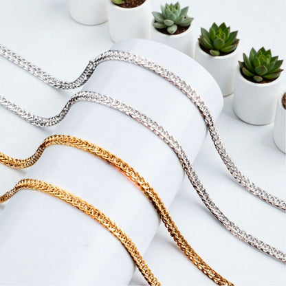 Chaîne homme, Collier à anneaux serrés dore argent presentation rouleau blanc plantes 