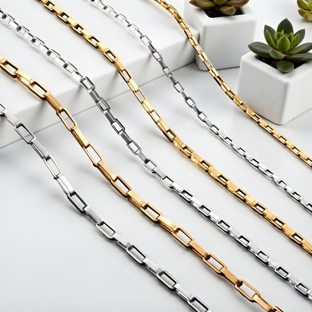 Chaine homme, Collier rectangulaire presentation grandeurs argentees doree table blanche