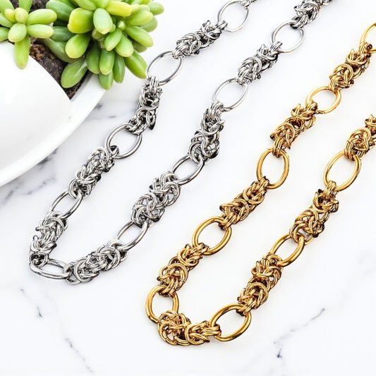 Chaine homme collier maillons entrelacés alterné doré et argenté presentation table marbre