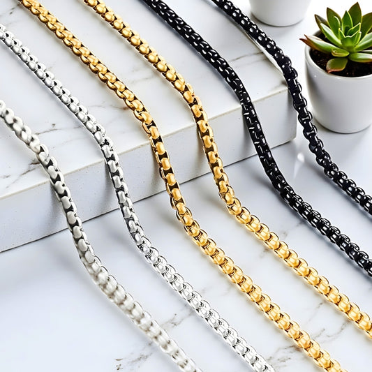 Chaine homme maille Rolo argent dore noir presentation marbre plantes