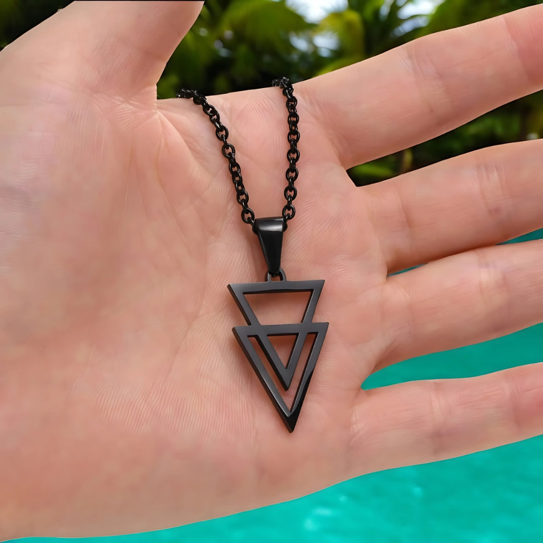 Collier-homme-pendentif-noirs-deux-triangles-inversés-main-présentation-plage-sud