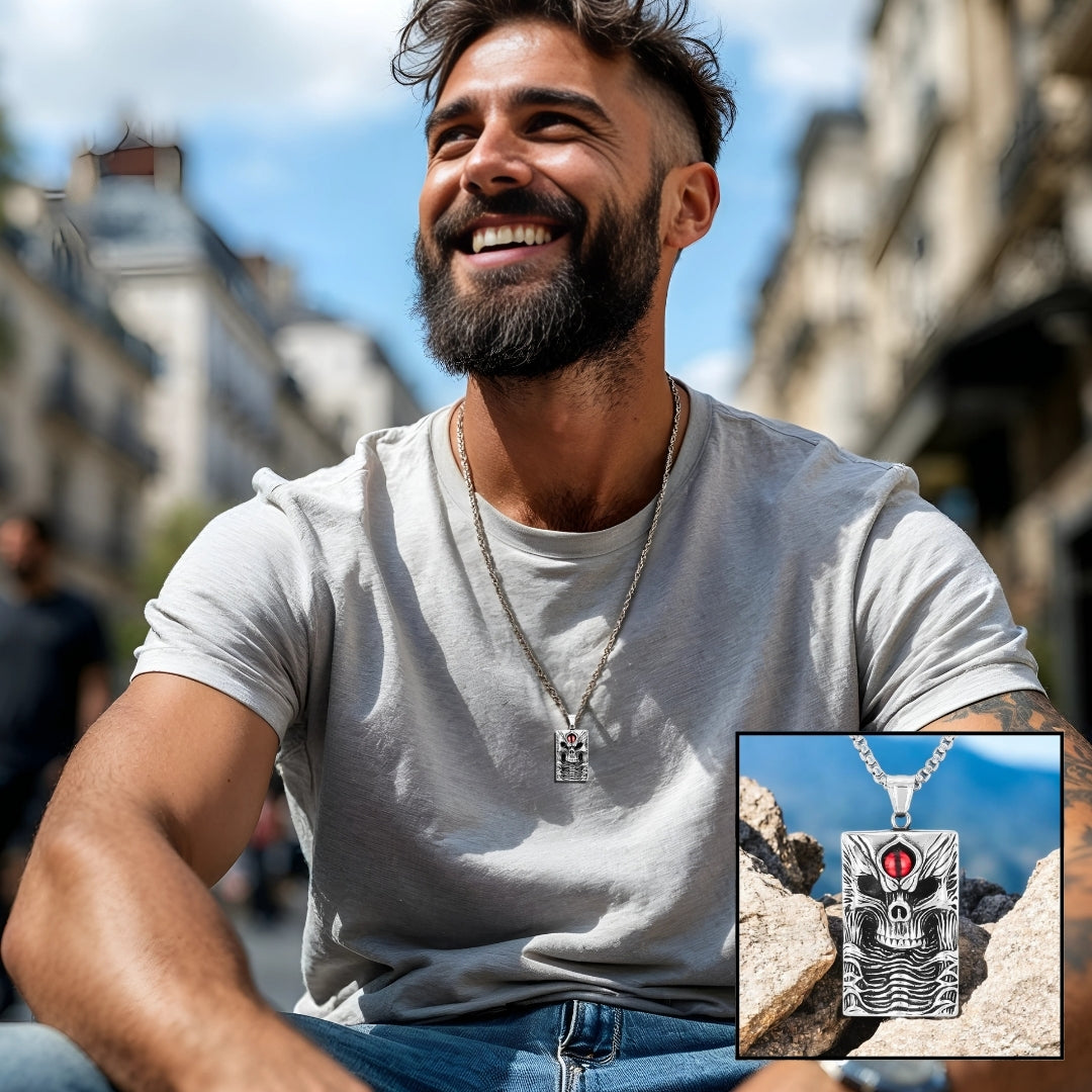 Collier homme- pendentif- tête de mort- skull- homme-élégant-t-shirt-gris-jeans- barbe- assied- à- Paris
