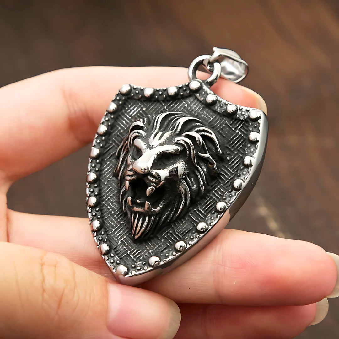 Collier hommes, pendentif BOUCLIER LION II™ presentation entre les doigts