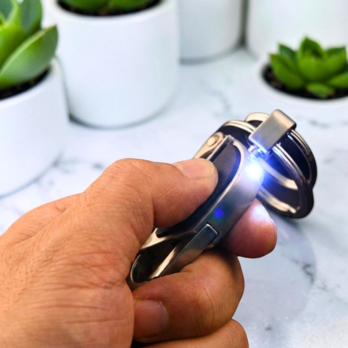 Porte-clé métal EDC avec lampe LED intégrée tenu en main