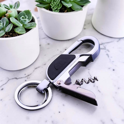 Porte-clé métal EDC avec tire-bouchon posé sur marbre