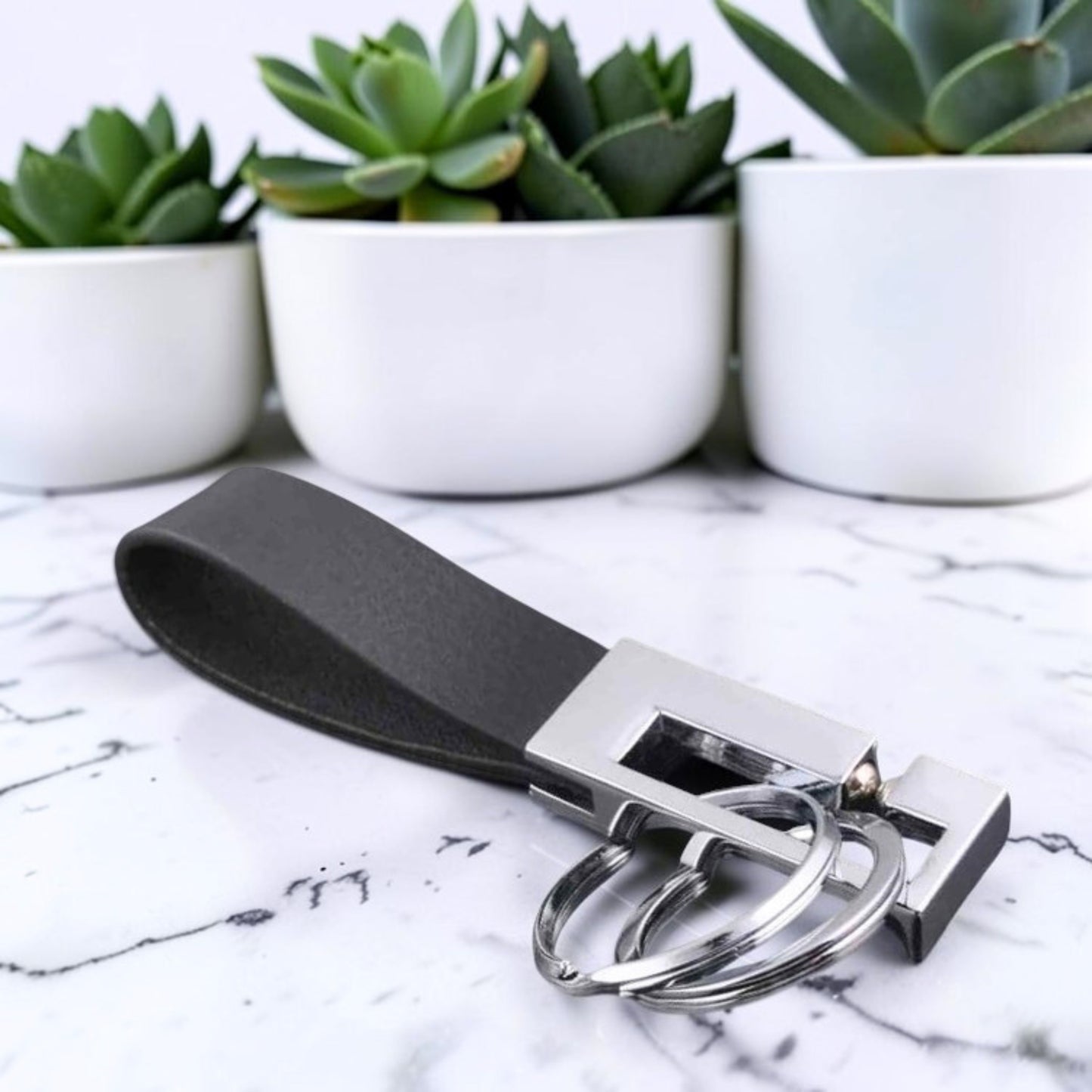Porte clés luxe | Élégance Cuir "Prestige" noir table marbre coté droit plantes